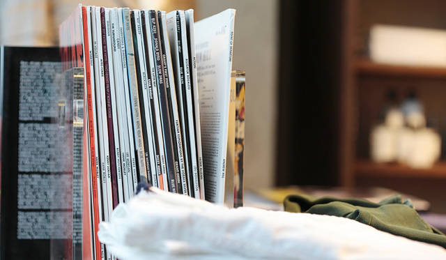 <strong>SLOWEAR｜スローウェア</strong>　ヴィンテージのテーブルに洋服とともに並ぶのは、レコードや新聞、グルーミングキットなどといった小物たち。