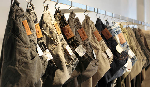 <strong>SLOWEAR｜スローウェア</strong>　ずらりと並んだデニムの数々。上質な素材は手に取れば柔らかく、シルエットとはき心地のよさを同時にかなえるスローウエアならではの逸品が取り揃う。