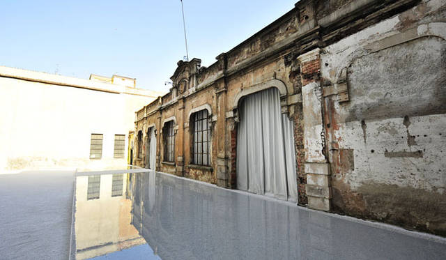 <strong>東芝｜TOSHIBA</strong>　space02 COURTYARD｜日中は太陽が、夜間にはLEDが、水面に絶え間なく生まれる波紋に光を当て、この地で100 年の時を刻んできた1 枚の壁に反射する。たゆたう水が、残された壁に光の時を与える。