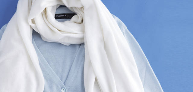 <strong>Hawick Cashmere of Scotland｜ホイック・カシミヤ・オブ　スコットランド</strong>　アイスブルーのVネックカーディガン 8万7150円、ホワイトのストール 5万2500円（ホイック・カシミヤ・オブ　スコットランド／ホイック・カシミヤ・ジャパン）