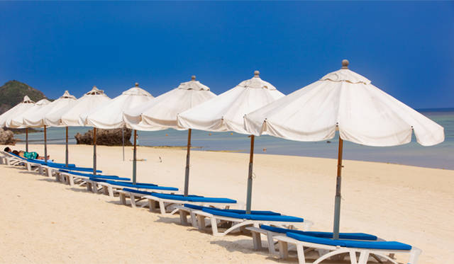 <strong>Club Med Kabira Beach, Ishigaki｜クラブメッド石垣島</strong>　ビーチパラソルの下、デッキチェアにころりと横になる。まぶしさに目がくらみ、自分自身も景色に溶け込んでいくような感覚。