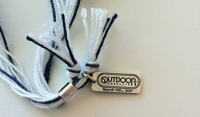 <strong>OUTDOOR PRODUCTS｜アウトドアプロダクツ</strong>　100本限定チャリティブレスレット　March 11th.,2011と刻印された「OUTDOOR PRODUCTS」のロゴ入りシルバープレート
