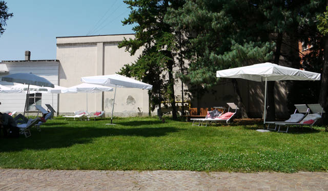 <strong>WHITE GIUGNO 2011｜ホワイト ジューニョ 2011年</strong>　建物に向かう途中には、白いパラソルとサマーベッドが。豊かな緑のなか、くつろげるコーナー。 