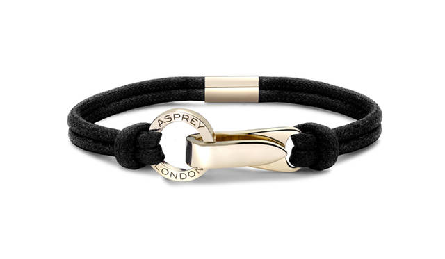 <strong>Asprey｜アスプレイ</strong>　アスプレイの最初の文字「A」をモチーフにつくられたクラスプデザイン。「Aライン リストバンド」[YGクラスプ×ブラックコットンコード] 36万5000円（アスプレイ／アスプレイ ジャパン）