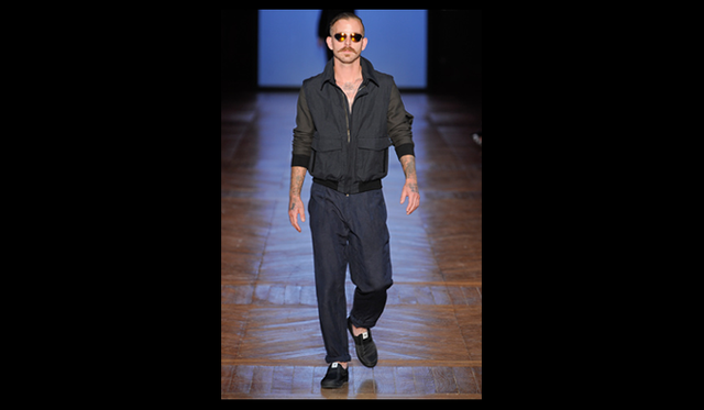 <strong>ADAM KIMMEL｜アダム キメル</strong>　今回のコレクションでは、外見ではなく、サーファーたちのスピリットを表現している。「サーファーたちは、彼らが着る服よりも断然クールな存在だと思う。僕の知っているハードコアなサーファーたち――誰も挑みたくないような波に果敢に向かって行く彼ら――は、サーフウェアは着ないし、いかにもサーファー的な格好は絶対にしない。そんな彼らのエッセンスを抽出し、表現したこのコレクションを、こう呼ぼう――サイケデリックな空気を帯びたダーク・サーフィング、と」（アダムキメル）。<br><br>コレクションのメインカラーは、ブラックとオリーブ。カスタムしたサイケデリックプリントやボタンなどは、このダークな春夏コレクションに色を与えるスパイスになっている。<br><br>  通気性の良いメッシュニットセーターには軽量のネオプレン製エルボーパッチをあしらい、ウェットスーツに用いられるステッチをほどこした。このステッチは、コレクションの随所に取り入れられている。リバーシブル・ブレザーや、サーフ・ワックス用のポーチがついた、襟と袖が取り外し可能なボンバージャケット、フードが取り外せる樹脂加工のコットンアウターといった今季ならではのアイテムは、着心地やフィット感を追求しながらも、ほっそりとしたシルエットにすることで、よりテイラードな仕上がりだ。「今まででもっともウェアラブルであり、僕自身とても気に入っているこの春夏コレクションを、はじめてのキャットウォーク・ショーで披露できることをとても誇りに思う」（アダムキメル）。