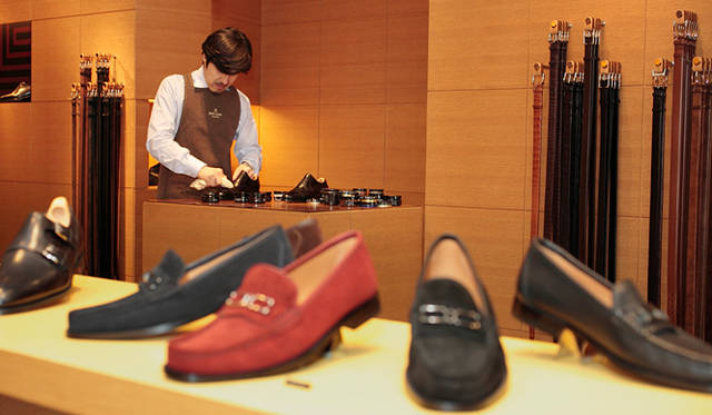 <strong>JOHN LOBB｜ジョンロブ</strong>　仕上げのワックス：ワックスは必ずしなくてはいけない、ということではありませんが、靴がより美しく、セクシーに見えますよね。光らせる部分は全体的なバランスもありますが、基本的にはトウとヒール部分。前と後ろを光らせることで全体のバランスがすごくきれいに見えるということと、歩いているときにテンションがかかような場所にワックスをすると、パラパラとはがれてきてしまうので、中に芯が入っているトウとヒール部分が適しているんですね。