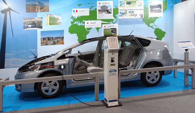<strong>あたらしい時代づくりに取り組むひとと企業──トヨタ自動車編</strong>　2011年6月、東京ビッグサイトで開催された「スマートグリッド展 2011」の模様。トヨタが各地で実証実験を進めているスマートグリッドの概要が説明され、プリウス プラグインハイブリッド、個人向けに販売される予定の充電スタンド「Gステーション」が展示された。