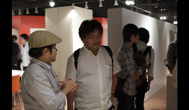 <strong>AAF通信｜U-30 記念シンポジウムI　開催レポート</strong><br />米澤 隆「パラコンテクストアーキテクチャー」　五十嵐太郎氏に作品の説明をおこないます。<br />Photo by Satoshi Shigeta ©Nacasa&Partners.Inc.