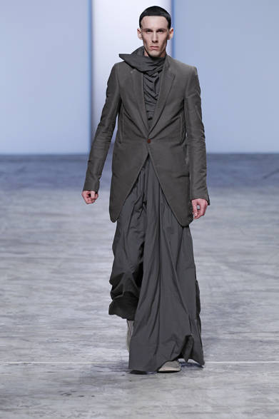 SS12_RO_2001 <strong>Rick Owens|リック・オウエンス</strong> 2012S/SのテーマはNASKA。「ナスカ」と呼ばれる、空から見える美しいペルーの膨大な古代の地上絵からインスパイアされている。コレクションでは、美しい建築物を彷彿させる放射線状にほどこされたジオグラフィックな模様と、リック・オウエンスが提案するあたらしいスリーピースが目をひいた。今回のショーで、ほぼすべてのルックにコーディネートされたロングチュニックやスカートは、斬新でありながらエレガントであるリックからのスリーピースの提案だ。ショートジャケット、ハリ感のあるスプリングコートにロングスカート、そしてさまざまな丈のチュニックで仕上げるスタイルは、ランウェイで魅せるショーならではの斬新なアプローチであり、リック・オウエンスの考える男性のエレガンスを醸し出している。リック・オウエンスの真骨頂といえる、美しいカッティングとシェイプが堪能できるコレクションだ。