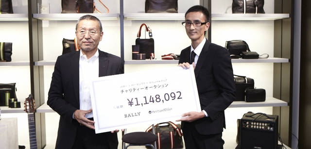 <strong>BALLY｜バリー</strong>　スペシャルライブのスタート時には、バリー・ジャパン代表取締役社長の酒井壽夫氏からモア・トゥリーズの和井健太郎氏へチャリティチェアプロジェクトの落札金額が記されたボードが手渡された。