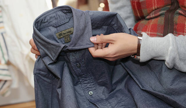 <strong>Nigel Cabourn｜ナイジェル・ケーボン　糸から開発した渾身のシャツ「BRITISH OFFICERS SHIRT」先行販売スタート！</strong><br />「じつは襟もとはボタンダウンなんです。普通は襟を貫通したカタチでボタンホールをほどこしますが、このシャツは襟の生地を2枚重ね、中に隠れるようにしています」