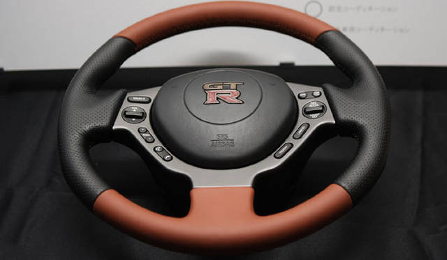 <strong>NISSAN GT-R｜日産 GT-R</strong>　エゴイストには伝統工芸士 久保田栄氏が、1カ月の時間をかけ丹精こめてつくりあげる輪島蒔絵のエンブレムが取りつけられたステアリングを採用。