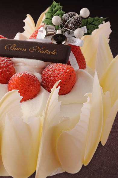 <strong>GRAND HYATT TOKYO｜グランド ハイアット 東京</strong><br />ストロベリーショートケーキ<br />しっとり焼き上げたスポンジにたっぷりのホイップクリームと真っ赤ないちごをふんだんに使用した、毎年大人気のひと品。ケーキのまわりをぐるりと飾ったホワイトチョコレートは、聖なるクリマスに舞い降りたエンジェルの羽根をイメージ。ダイナミックなビジュアルがテーブルを華やかに彩る。<br /><br />価格｜4200円（12cm）、6000円（15cm）<br />予約期間｜12月16日（金）まで<br />受け渡し期間｜12月17日（土）～25日（日）<br />販売店舗｜グランド ハイアット 東京1F『フィオレンティーナ ペストリーブティック』