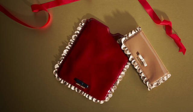 　鮮やかな発色の艶やかなパテントはレッド、ピンク、そしてフリルにリボンというキュートなディテール……女の子の好きなものを詰め込んだような、スイートなデザインで甘いひとときを演出して。<br />iPadケース　3万8850円、フラップウォレット　5万400円（ともにミュウミュウ／プラダジャパンカスタマーリレーションズ　Tel. 0120-559-914）