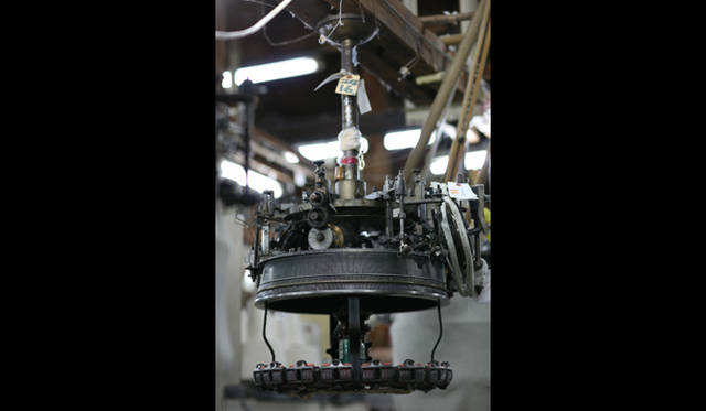 <strong>LOOPWHEELER｜ループウィラー</strong>　和歌山の工場のようす・カネキチ工業　　「編むスピードを上げるには、糸もピンと張らないと絡まってしまいますし、編み上がった生地をおなじスピードで巻き取ってあげないと、できあがった生地が出口につまって機械が止まってしまいます。ようするにスピードを上げるためには、つねに糸に緊張感を与えなくてはなりません」