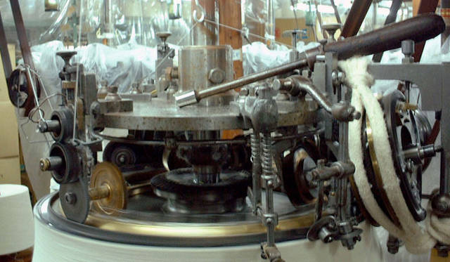 <strong>LOOPWHEELER｜ループウィラー</strong>　和歌山の工場のようす・カネキチ工業　「吊り編み機は、糸にほとんどテンションをかけずに編める編み機です。どんなものを編むかによって多少異なりますが、1分間にだいたい24回転、それが平均スピード。はっきりと目で追える速さです」