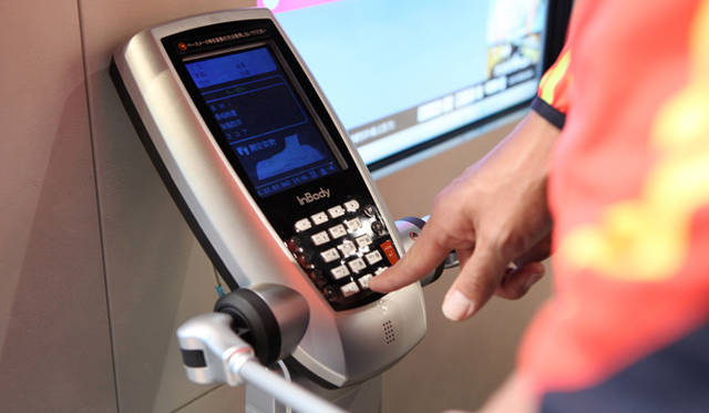 <strong>ランナー必見！　松浦俊夫による「Running Dock」体験レポート</strong>　チェック①：InBodyによる体成分分析<br />身体をスキャンするイメージで、専用の測定器を使用し、体脂肪、筋肉量、水分量など、ランニングをおこなううえで必要となる身体の体内状態をチェックする。年齢、性別を登録し、あとは台の上に立っているだけ。そのまま待つこと2分弱、測定結果はすぐにプリントアウトされ、すべての測定を終えたあと、最後におこなわれるトレーニング指導のさいにそのほかの測定結果とともに詳細な説明を受けることに。