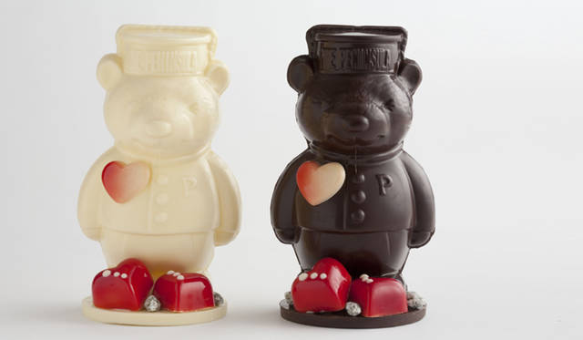 <strong>THE PENINSULA TOKYO｜ザ・ペニンシュラ東京</strong><br />バレンタイン チョコレートベア　各4500円（約15cm）<br />ザ・ペニンシュラのアイコン的存在のページボーイの制服を着たベア型のチョコレートに、キュートな赤いハートのチョコレートがほどこされたバレンタインバージョンのチョコレートベア。ベアの中には、ビター、ミルク、ホワイトの9個のボンボンショコラが入っている。
