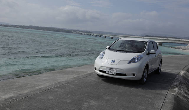 <strong>NISSAN LEAF｜日産 リーフ</strong>　潮風に吹かれながら撮影。背後に見えるのが、沖縄県最長の橋、古宇利大橋。