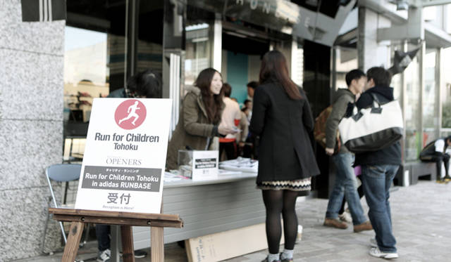<strong>Run for Children Tohoku in adidas RUNBASE</strong><br />午後13時、『アディダス ランベース』入口に設置された受付カウンターにぞくぞくと集まる参加者たち。参加費としていただいた2000円は、全額JustGiving Japanをとおして「ハタチ基金」へ寄付された。