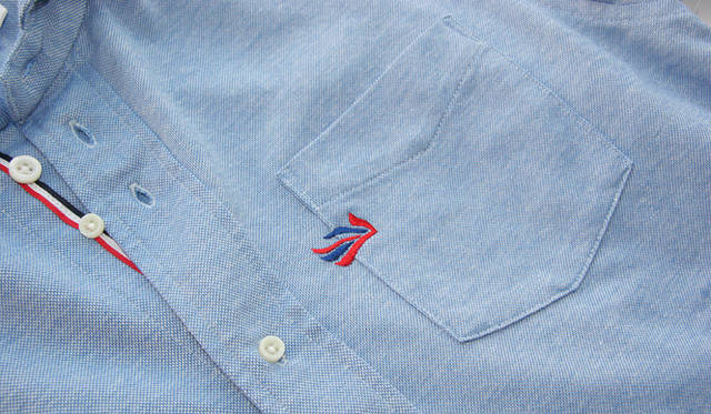 <strong>flaph × BARNEYS NEYORK</strong>　胸ポケットに刺繍されたブランドロゴはユニオンジャックをアレンジしたもの。フラフのアイデンティティをポップに物語る。