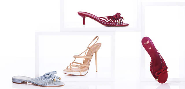 <strong>BALLY｜バリー</strong>　1950年代のアーカイブからインスピレーションを得たというラインは、リボンやあや取りがモチーフ。この春夏トライしたい、50年代ふうな着こなしにもばっちりはまることは間違いない。紐が複雑に配されていることで、履いたときに安定感があるのもうれしい。左から／水色のリボン付きフラットサンダル [H1cm] 6万1950円、ヌードカラーのストリングサンダル [H13cm] 8万2950円、赤のリボン付きサンダル [H5cm] 7万350円