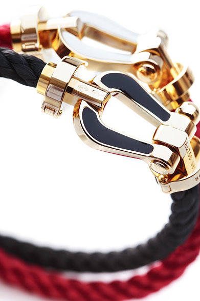 <strong>阪急MEN’S TOKYO｜5月 “サマー アトラクション”</strong>　通常のバックルは表面のYGのみだが、ポップアップブティックオープン期間中、YGバックルの裏側にエナメル加工（ブラック・ホワイト・ブルーの3種、そのほかレッド・オレンジ・ピンクはオーダー受付）をほどこした数量限定の「フォース10」ブレスレットと2連のホワイトケーブルも展開