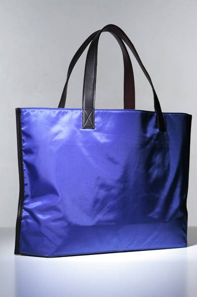 光沢あるナイロンツイル使いのトートは、スーツスタイルにも対応するスマートな印象。弱撥水加工を施した素材なので、ちょっとした雨なら防げる優れものだ。裏返せばもっとも定番的なキャンバス地のトートに変身。オフにはキャンバス地の面を存分に活用してほしい。H36×W57×D13cm。<br /><br />2万5725円（ポーター）<br /><br />吉田<br />Tel. 03-3862-1021<br />http://www.headporter.co.jp/