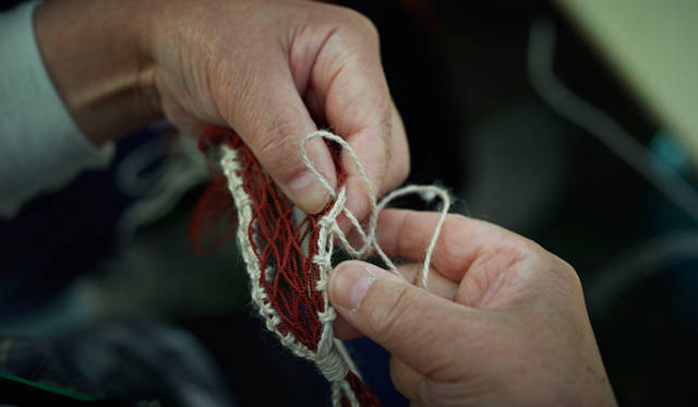 <strong>浜のミサンガ「環」</strong>　風合いのある白の麻紐とえんじの魚網を組み合わせたオリジナルのミサンガは、ひとつひとつ彼女たちの手作業でつくられている
