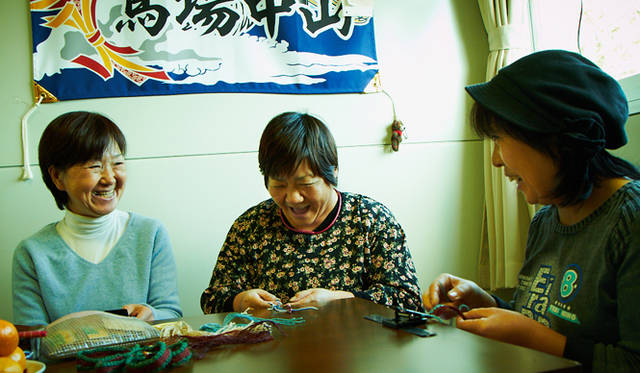 <strong>浜のミサンガ「環」</strong>　浜の女たちがひと編み、ひと編みに希望や三陸の復興への願いを込めてつくったミサンガは、被災地と私たちをつなげる“環（わ）”となっている