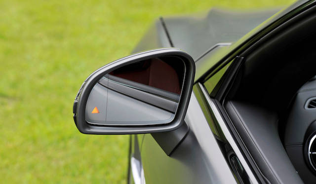 <strong>Mercedes-Benz SL550 BlueEFFICIENCY｜メルセデス・ベンツSL550ブルーエフィシエンシー</strong><br />サイドミラーの三角は、最近のメルセデス各モデルに装着される、死角に入った他車を感知すると点灯する「アクティブブラインドスポットアシスト」のインジゲーターだ