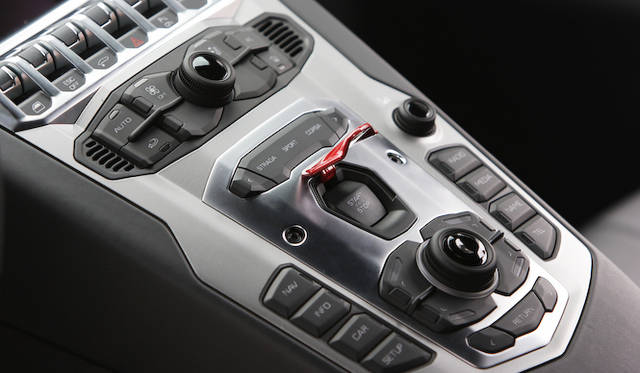 <strong>Lamborhghini Aventador LP 700-4｜ランボルギーニ アヴェンタドール LP 700-4</strong><br />猛牛を目覚めさせるスイッチは誤作動を避けるため、カバーでおおわれる。そのすぐ上にあるのがモードスイッチで、コンフォート志向の「ストラーダ」、スポーティな走行に最適な「スポーツ」、サーキットなど特別な走行向けの「コルサ」がある。