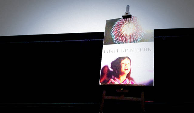 壇上におかれたドキュメンタリー映画『LIGHT UP NIPPON 日本を照らした奇跡の花火』のポスター