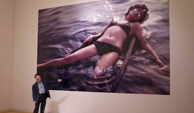 <strong>「篠山紀信展 写真力　THE PEOPLE by KISHIN」</strong>　実物大の作品を使って展示実験中の篠山紀信氏（写真提供：東京オペ ラシティ アートギャラリー）