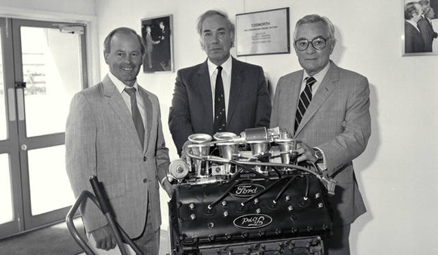 1986年 400基目のフォード・コスワース DFV エンジンと 左から コスワース エンジニアリングの創設者 マイク・コスティン（Mike Costin） 開発者 キース・ダックワース（Keith Duckworth） フォードのF1活動に深くかかわったジャーナリスト ウォルター・ヘイズ（Walter Hayes）