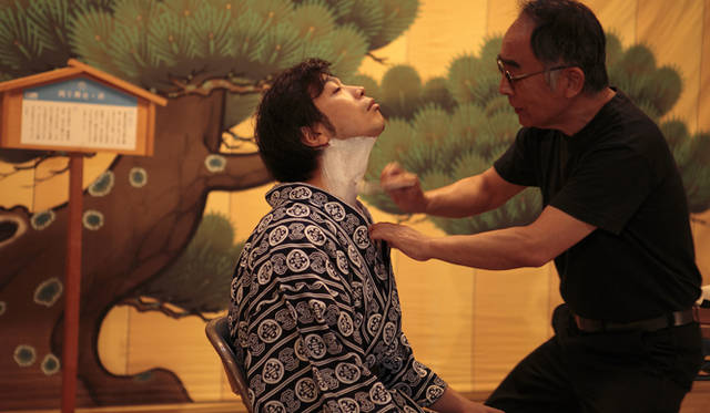 <strong>森の神に会う旅～岐阜県の“ウェルネス・ツーリズム”</strong>　右が東濃歌舞伎保存会の事務局長で、振付師でもある吉田茂美さん。「顔師（かおし）」の領分である化粧だが、振付師が兼ねる場合もある。一気に下地を塗る