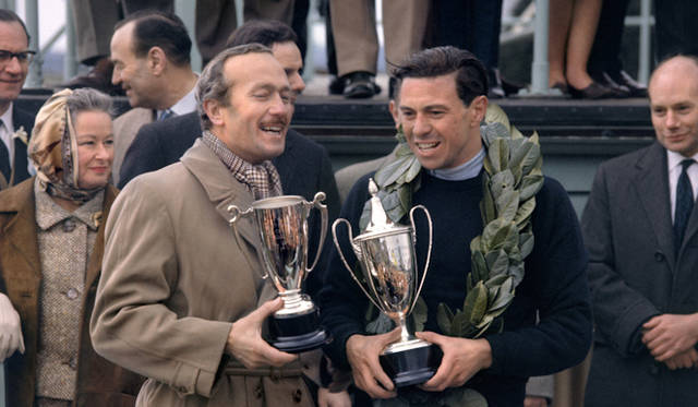 <strong>Colin Chapman and Jim Clark ｜コーリン・チャップマン&ジム・クラーク</strong><br />1964年のグッドウッド・フェスティバルにて　ロータス創始者のチャップマン(左)と、その彼に才能を見出された天才F1レーサーのジム・クラーク(右)