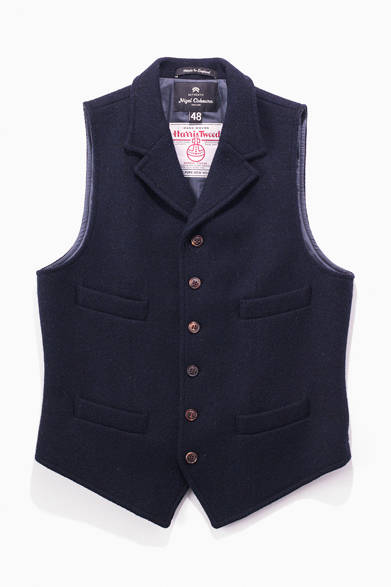 ナイジェル・ケーボンのネイビーのベストは、「そこに山があるから」という名言でお馴染みの英国の登山家、ジョージ・マロリーが着ていたものをベースに製作。前身頃だけでなく後身頃にもハリスツイードを使うことで、優れた保温性を実現しつつ、クラシックなムードを醸し出している。<br /><br />3万7800円（ナイジェル・ケーボン）<br />アウターリミッツ<br />Tel. 03-5457-5631