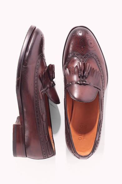 タッセルスリッポンは紳士の定番であるが、こちらはフルブローグでエプロン（キルト）付きという、その上をいくエレガンスを備えている。トゥ、ブローグ、シーム部分の色味が濃くなるよう手で染めるなど、アルチザン的こだわりも随所に見受けられる。<br /><br />8万4000円（グッチ）<br />グッチ ジャパン カスタマーサービス<br />Tel. 03-5469-6611