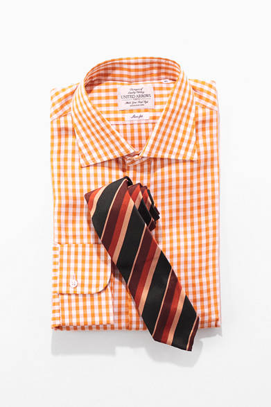 山吹色のギンガムチェックという陽気な柄のドレスシャツと、過去のアーカイブをモチーフにしながらも、現代的にアップデイトされたニッキーのストライプタイ。どちらも深みのある、それでいて鮮やかな色味が特徴だ。ダークな色のスーツはもちろん、明るいトーンのグレイスーツとも相性のいいVゾーンである。<br /><br />シャツ1万3650円（ユナイテッドアローズ）<br />タイ1万4700円（ニッキー）<br />ユナイテッドアローズ 銀座店<br />Tel. 03-3562-7798