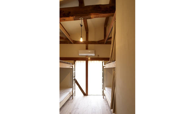 <strong>カフェ＆ドミトリー「山ノ家」</strong>　ドミトリーには、地元大工とインターンの若者たちがともに汗を流してリノベーションしたシンプルな空間に2段ベッドを2部屋にわたり9台設置　© Masayuki Hayashi
