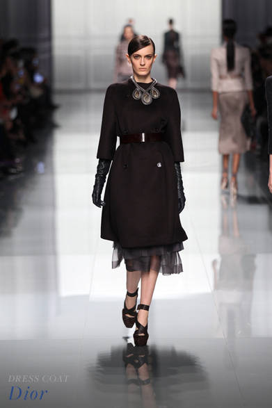 <strong>Dior｜ディオール</strong><br /><br />奥深い色合いに落ち着きのある豊かな女性像を思わせるクラシカルなコート。シックなブラックレザーのロンググローブが媚びない強い女性像を思わせる反面、裾から溢れるドレスの繊細なシフォンのピュアな透明感でスタイルに抜け感を。スタイリングの足し引きはぜひ参考にしたい。<br /><br />コート 参考商品<br /><br />クリスチャン ディオール<br />Tel. 0570-200-088