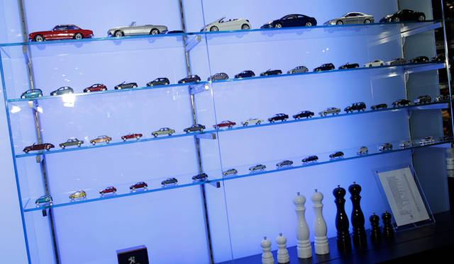 <br />プジョーのミニカーと製品がならぶ