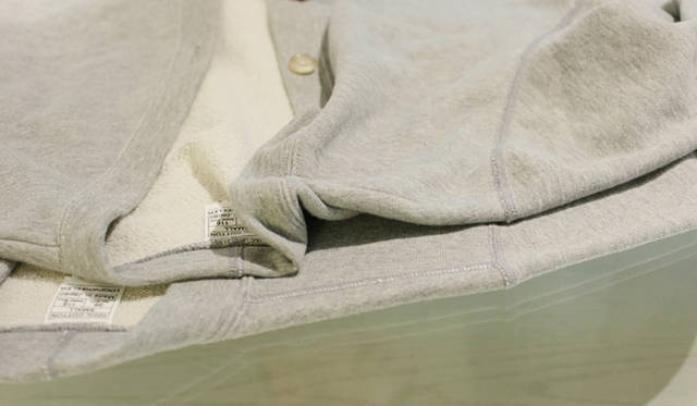 <strong>LOOPWHEELER｜ループウィラー</strong> 下に敷かれているのがループウィラーの定番スウェットカーディガン。今回の別注モデルは肩のシームが目立たないように仕上げられている