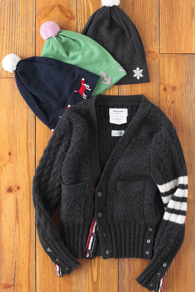 トム ブラウンらしい丈の短いカーディガン。フロントと袖のパイピング、左腕のラインがアクセントになり、フォーマルスタイルにほどよく遊び心を演出できる。ぼんぼんのついたニットキャップは、ビーグルや碇、雪の結晶の柄が愛らしい。<br /><br />ニットキャップ 各3万6750円<br />カーディガン 4万6200円（すべてTHOM BROWNE）<br />クロスカンパニー<br />Tel.03-5770-5570