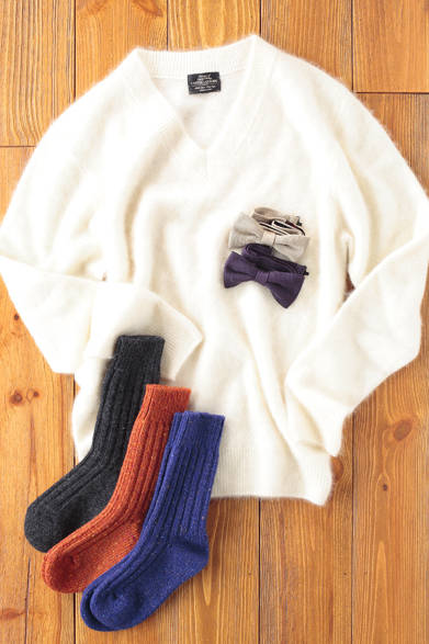 カシミア素材を使用したVネックセーター。毛足を生かしたヘアリーな表情が特徴で、ほっとするようなソフトな印象だ。ネック部分のリブ使いはやや太めにし、華奢になり過ぎないようにデザインされている。ボウタイはスカーフやタイなどのネックウェアを中心に手がけるフィオリオというブランドから。ソックスは、シェットランドウールを用いたニットアイテムで有名なブランド、マックリッチのもの。<br /><br />セーター 2万5200円（UNITED ARROWS）<br />ボウタイ 各9975円（FIORIO）<br />ソックス 各3780円（Mc Ritchie）<br />ユナイテッドアローズ 原宿本店 メンズ館<br />Tel. 03-3479-8180