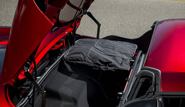 <strong>McLaren MP4-12C Spider｜マクラーレン MP4-12C スパイダー</strong><br />キャビン後方の専用スペースへと収納されるルーフ。クローズ時はここが52リットル分のラゲッジスペースになる。写真奥に写るのは専用のケースで、手前側にもうひとつ収納が可能だ