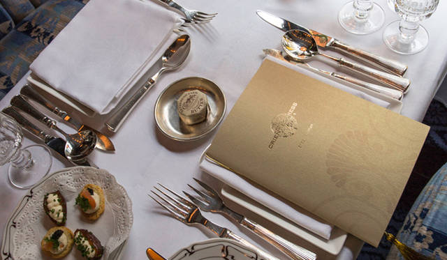 <strong>伝統と革新の英国ロイヤル文化を巡る旅</strong>　純白のテーブルクロス上には、美しい銀食器と輝くクリスタルガラスが優雅にセッティング