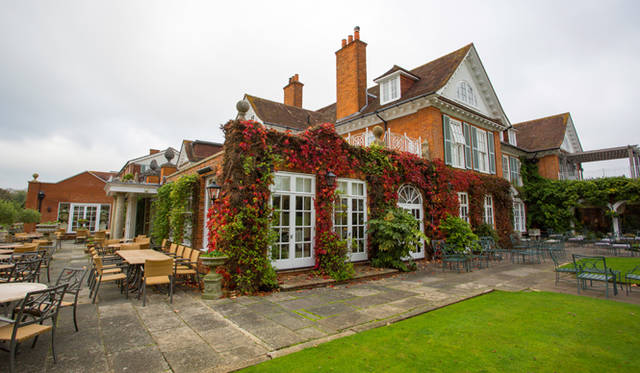 <strong>伝統と革新の英国ロイヤル文化を巡る旅</strong>　伝統的なレンガ造りの本館を囲むように広がるイングリッシュガーデン。テラス席も設けられ、アフタヌーンティーを愉しむにはこれ以上にない場所だ