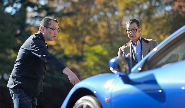 <strong>Ferrari 458 Spider｜フェラーリ 458スパイダー</strong><br /><strong>渡辺</strong>　専門家たちに言わせると、特に「458」のデザインは空力でつくっているデザインだそうです。ライトの横の穴であるとか、フェンダーの穴はエンジンの熱を抜く、煙突効果があるものだとか……時速200kmくらいになると、フロントの羽根も、フレキシブルに動くのですが、それでクルマを下に押し付ける力を増すということです。